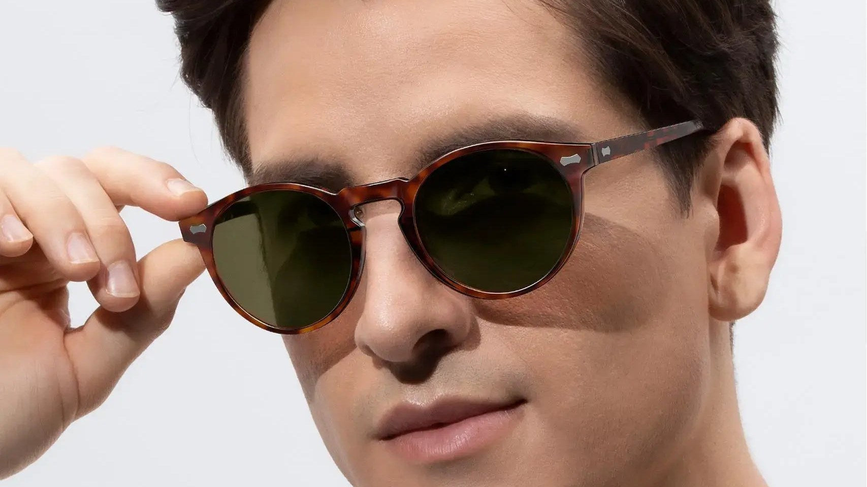 Man wearing tortoise round polarized sunglasses with green lenses