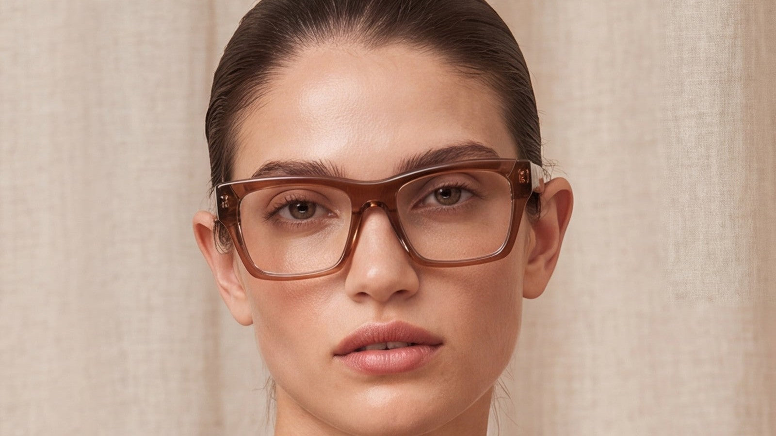Woman wearing brown acetate prescription glasses against a linen backdrop