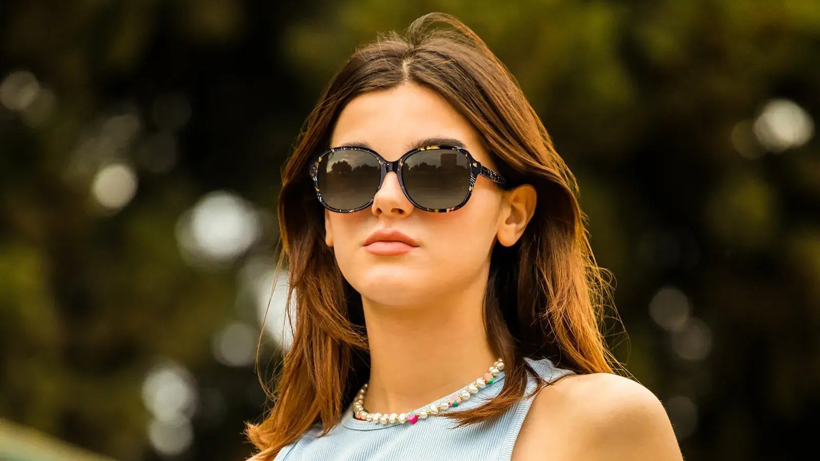 Woman wearing tortoise round sunglasses outdoors