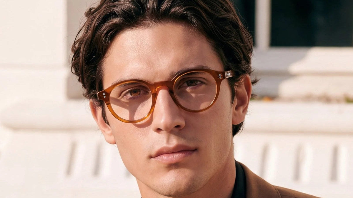 Man wearing round orange acetate glasses outdoors, a frame choice for balancing eye spacing