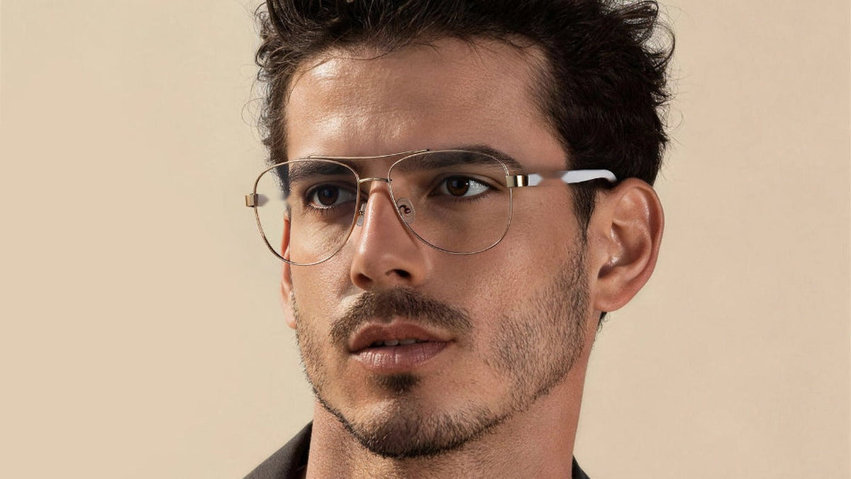 Man wearing gold aviator glasses against a warm beige background