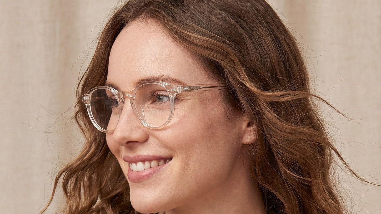 Woman with a heart-shaped face wearing clear round prescription glasses