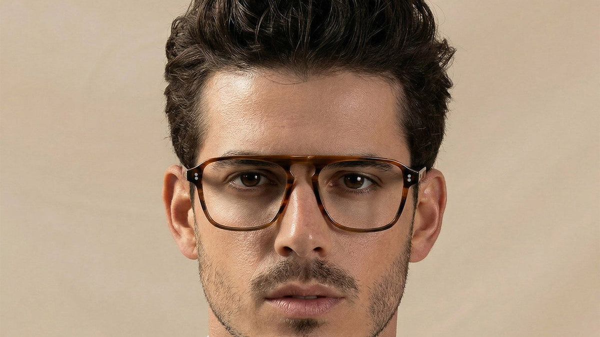 Man wearing brown tortoise double-bridge eyeglasses that balance a high forehead