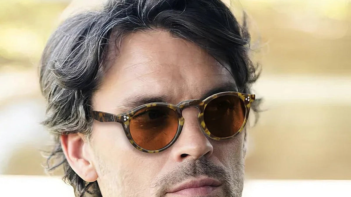 Man wearing round tinted glasses outdoors