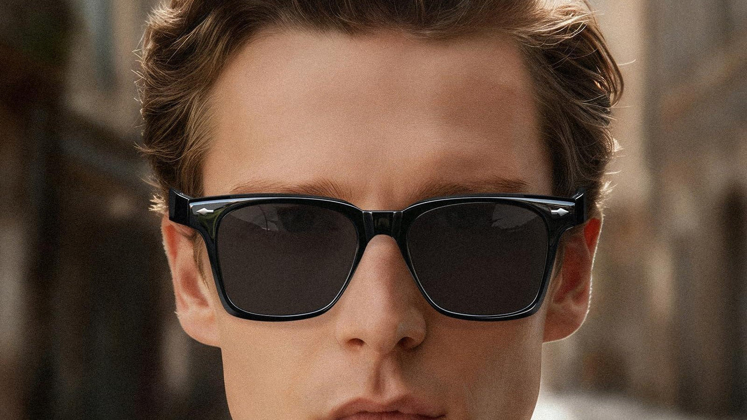 Man wearing black square sunglasses on a city street