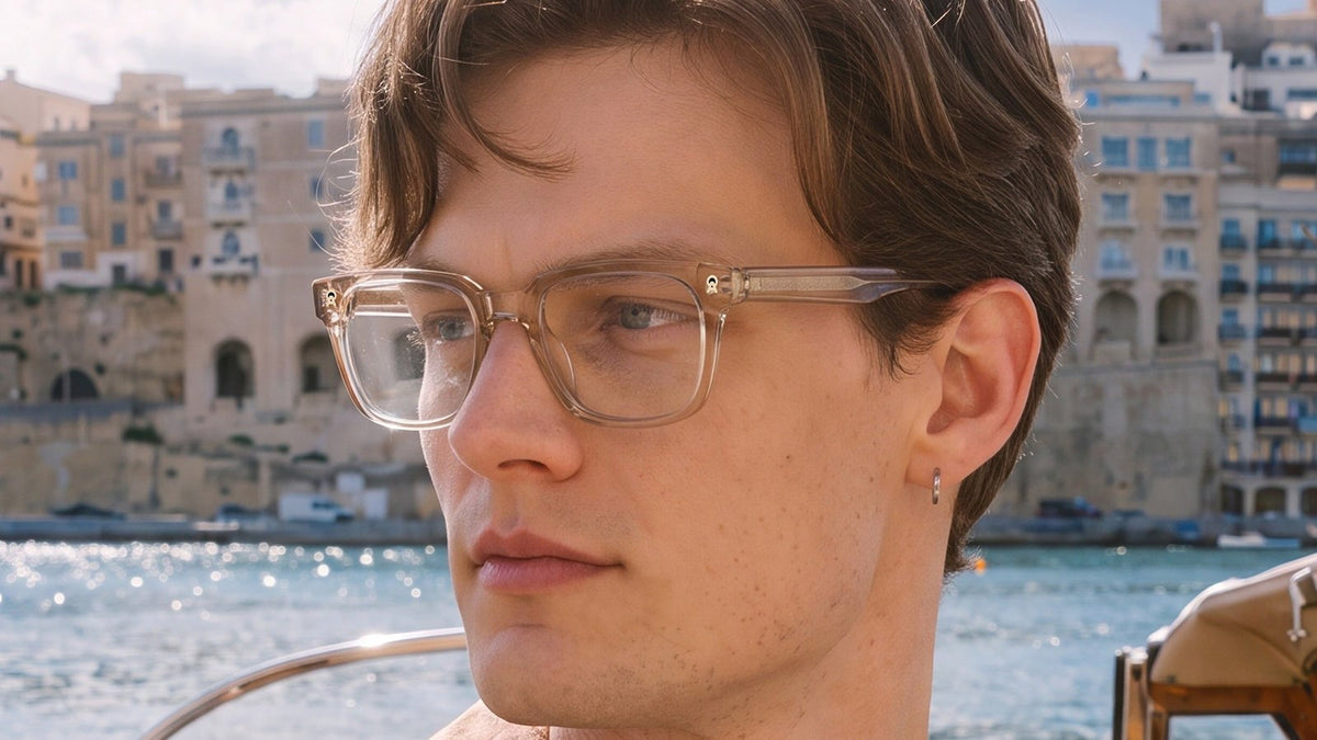 Man wearing clear gold rectangular glasses by the waterfront