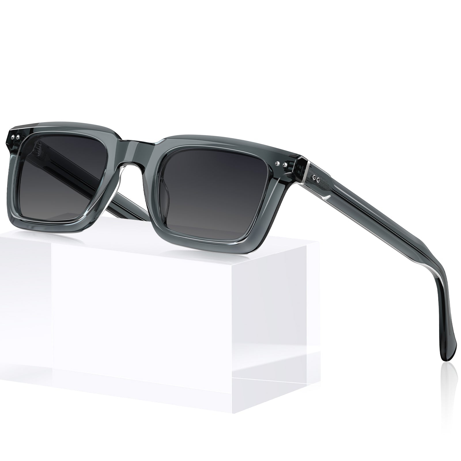 Gray acetate square sunglasses with dark lenses, displayed on a white geometric block against 